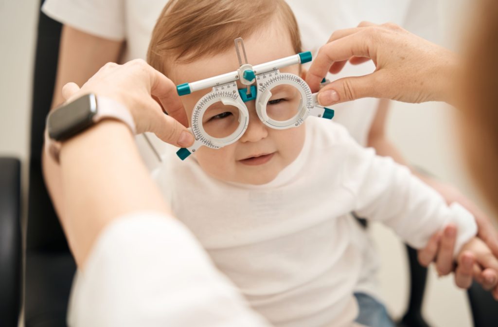 An optometrist fitting an infant with corrective lenses.