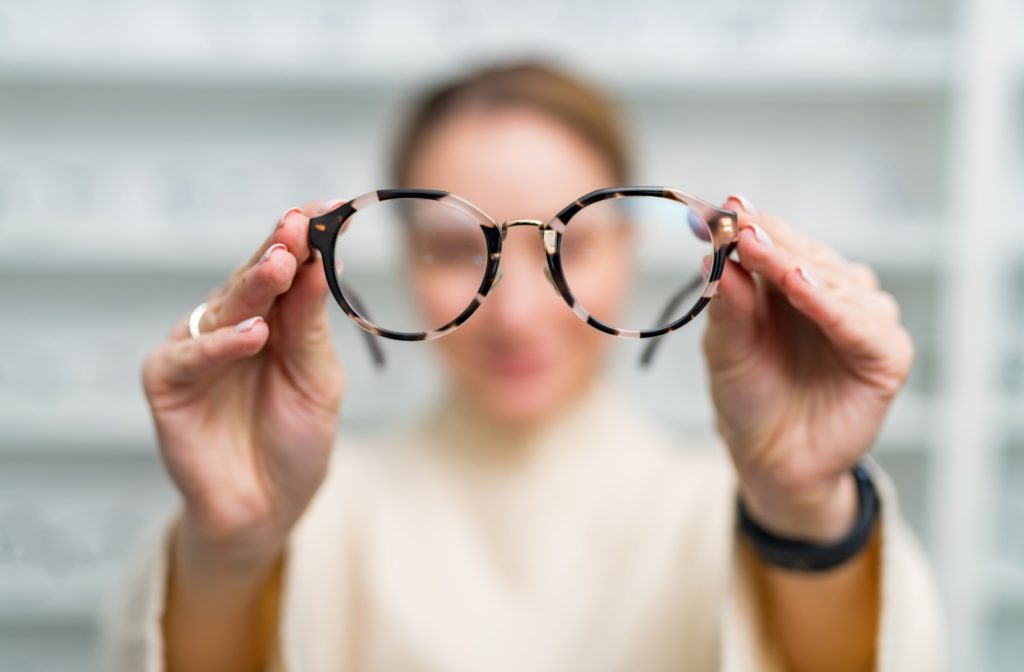 A closeup of someone holding up a pair of glasses