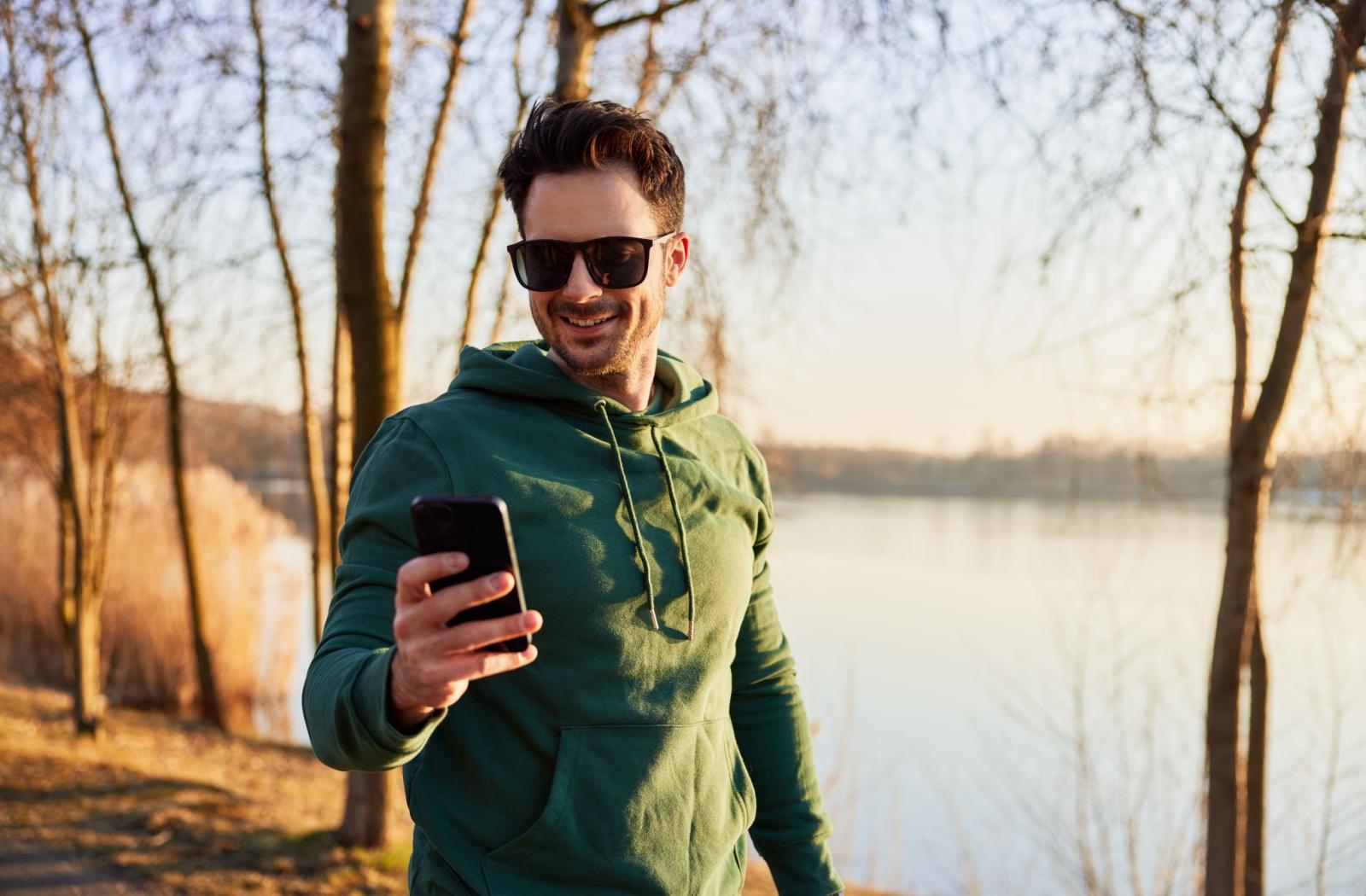 A person outside on a walk wearing sport sunglasses.